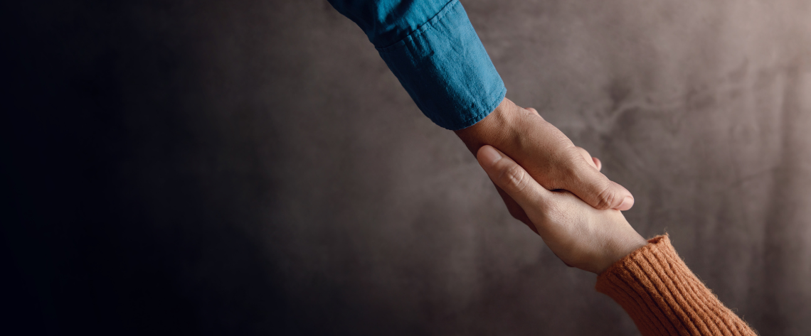 Eine reichende Hand und eine hilfeannehmende Hand